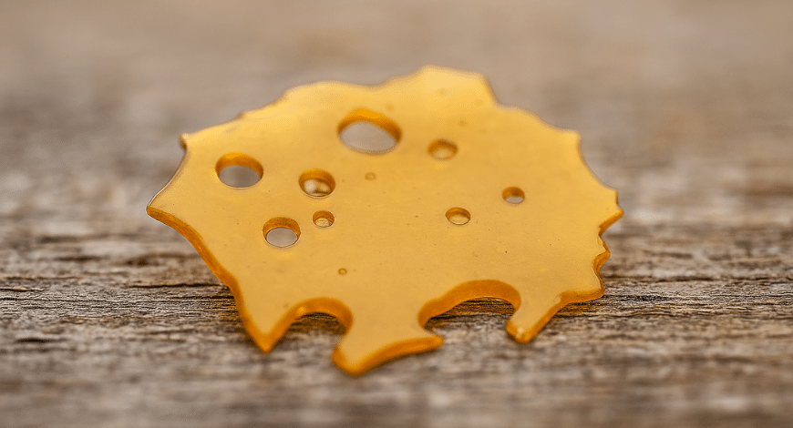 Glass-like cannabis shatter on a table, helping users understand what is shatter weed