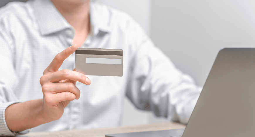 Person holding a credit card while shopping online—symbolizing a purchase of the Mandarin Cookies strain