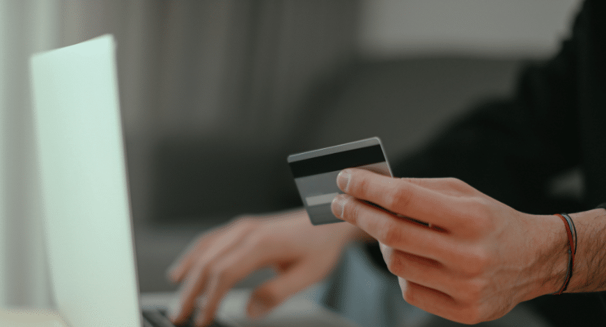 Person holding a credit card and shopping online, representing where to buy sativa weed online in Canada