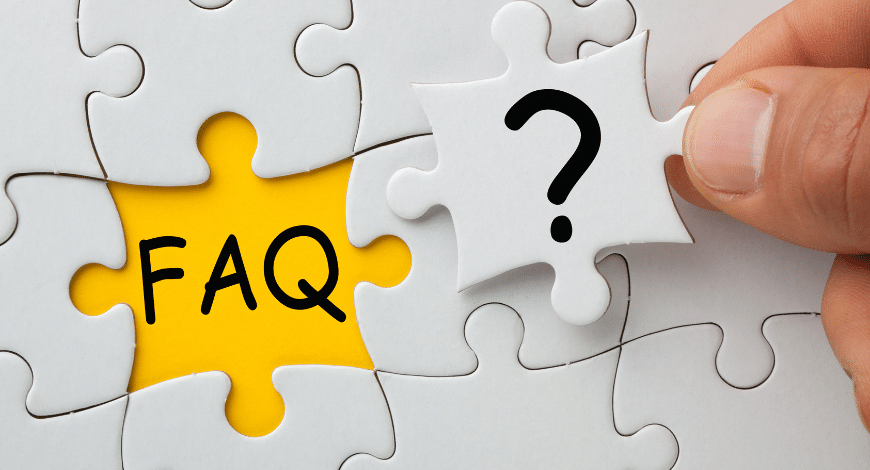 Hand placing puzzle piece with question mark into a puzzle revealing the word “FAQ,” symbolizing frequently asked questions.